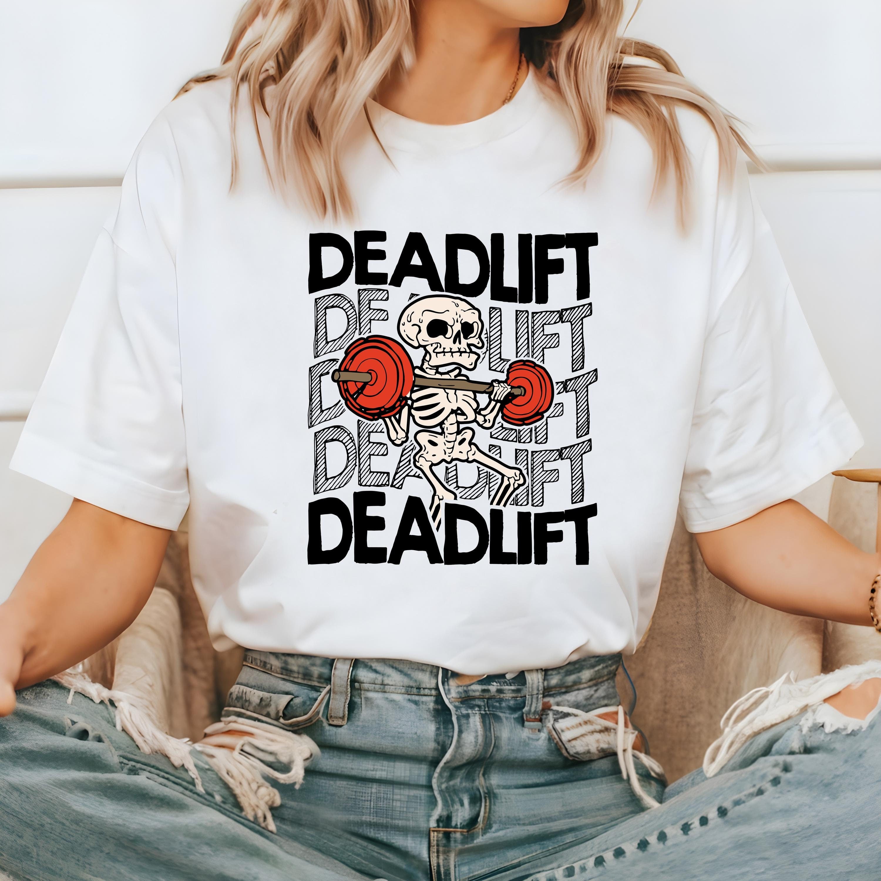 Dead lifting skeleton on a white comfort colors t shirt.